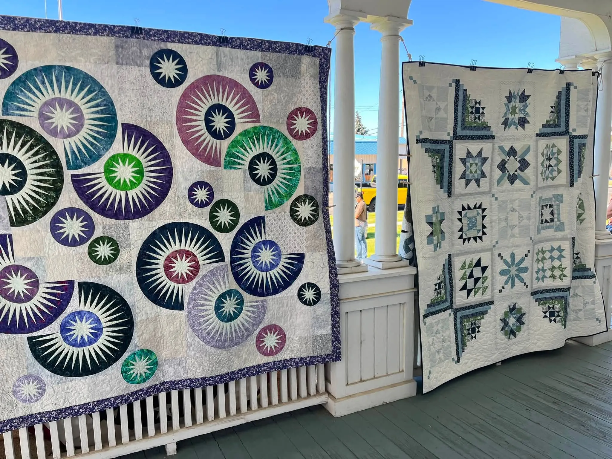 Modern quilt of concentric circles in blue, green and purple on the museum porch